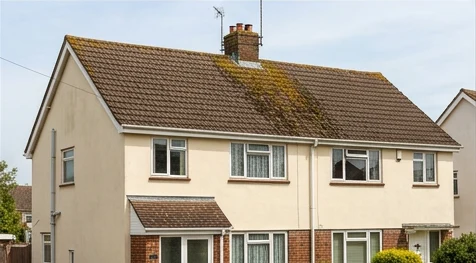 Illustrative cream home with moss on weathered brown concrete tiles